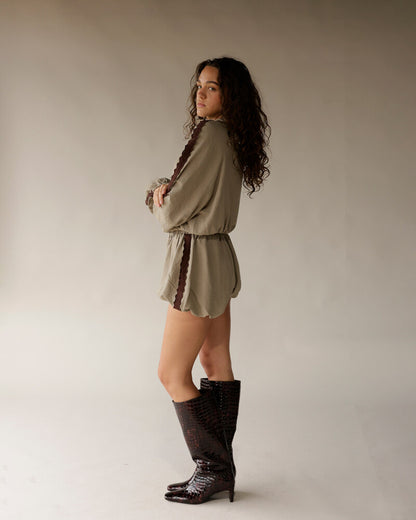 Olive green romper with brown lace trim and dark crocodile knee-high boots