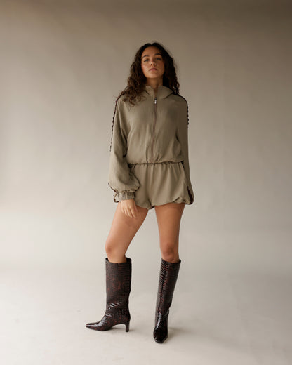 Sage green bubble shorts with elasticated waist, worn with matching zip-up jacket and dark croc boots.