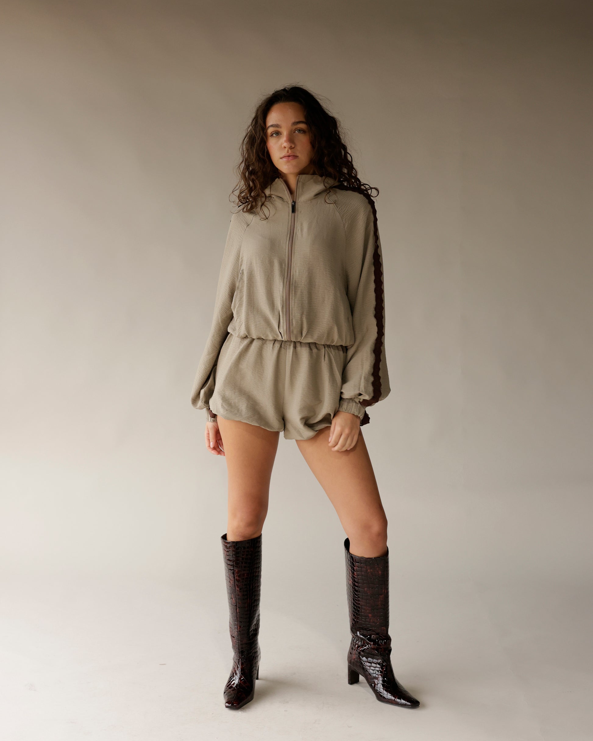 Tall dark brown crocodile embossed knee-high boots with block heel, worn by model