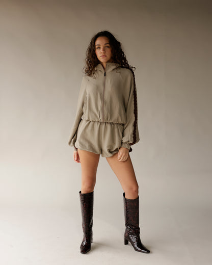 Tall dark brown crocodile embossed knee-high boots with block heel, worn by model