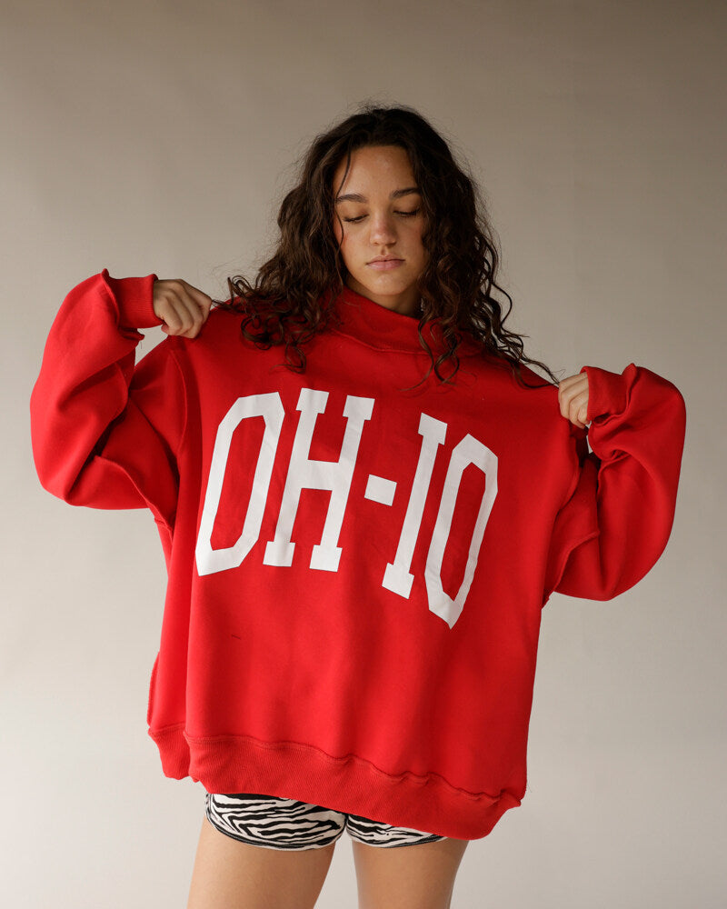 Oversized red mock neck sweatshirt with bold white OH-IO graphic lettering