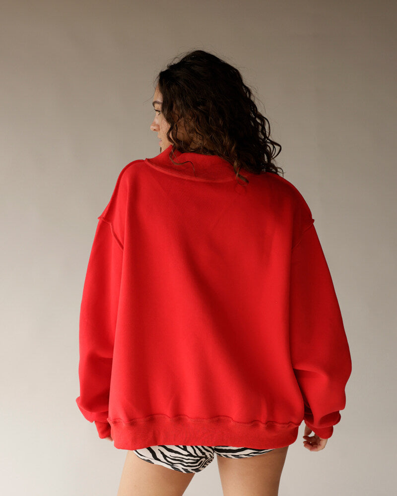 Oversized red mock neck sweatshirt shown from back, paired with zebra print shorts
