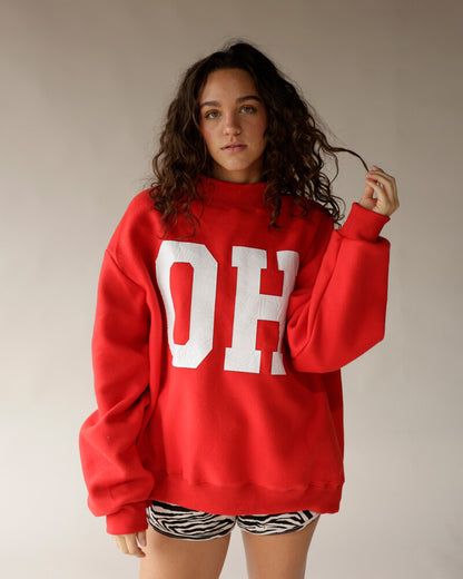 Red oversized mock neck sweatshirt with white OH lettering and zebra print shorts