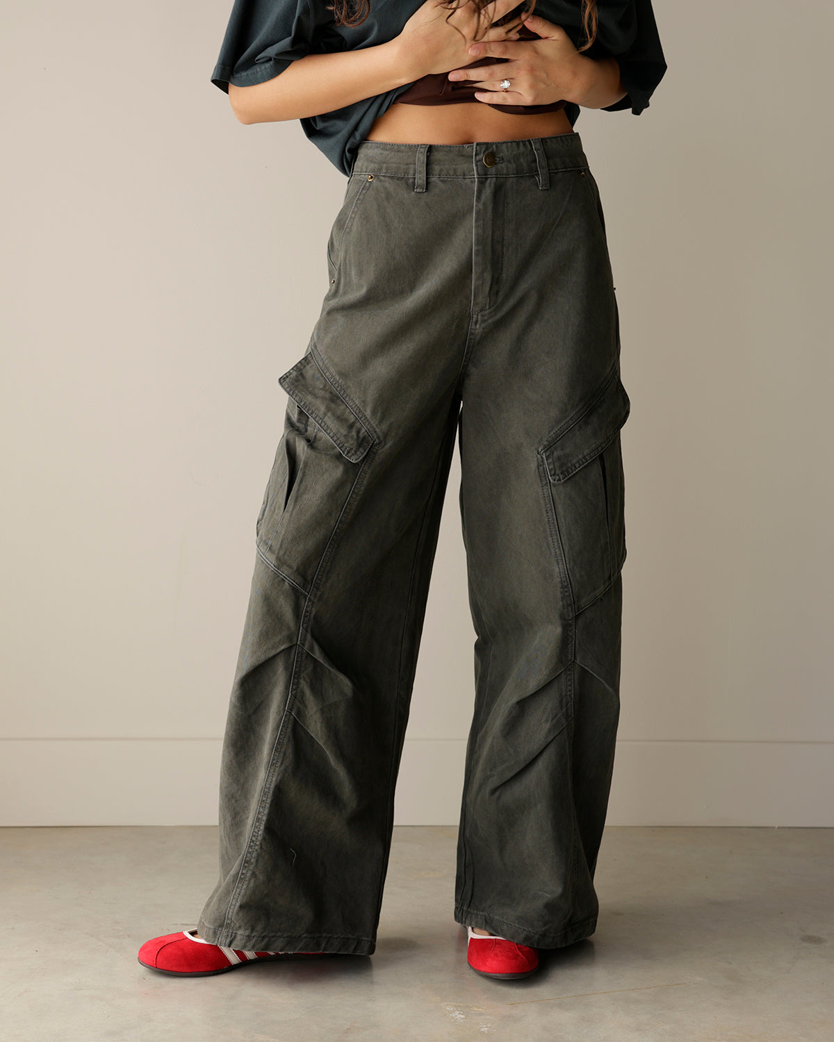 woman wearing mimosa washed charcoal-olive wide-leg cargo pants with oversized flap pockets, belt loops and a relaxed utility-inspired fit.