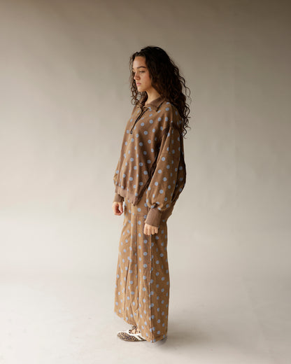 Mocha brown wide-leg lounge pants with blue polka dot pattern, worn with matching top