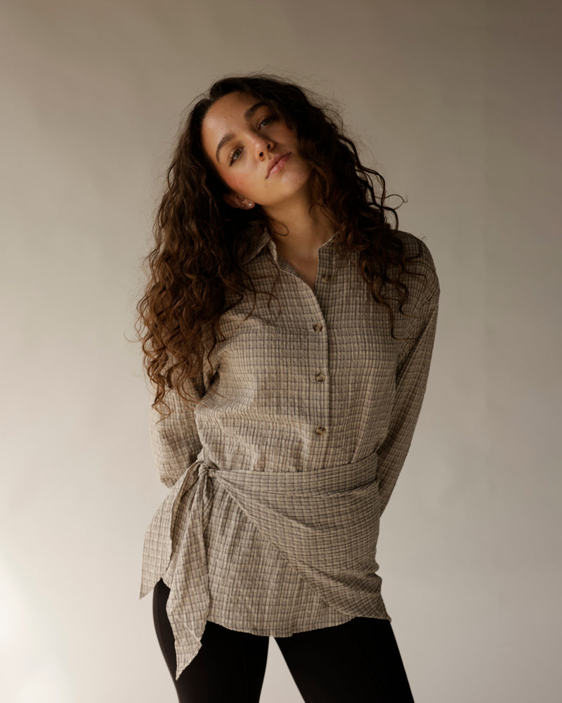 Black slim-fit capri pants styled with a belted plaid linen shirt on female model