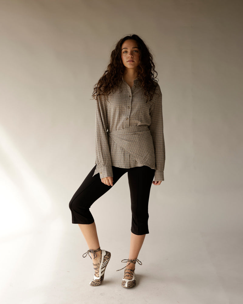 Black cropped capri pants worn with plaid shirt and lace-up leopard flats
