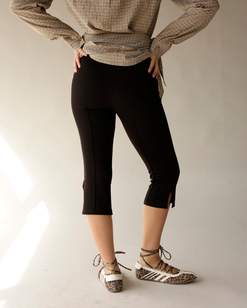 Black capri pants with front seam and ankle slits, styled with plaid top