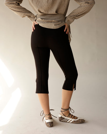 Black capri pants with front seam and ankle slits, styled with plaid top