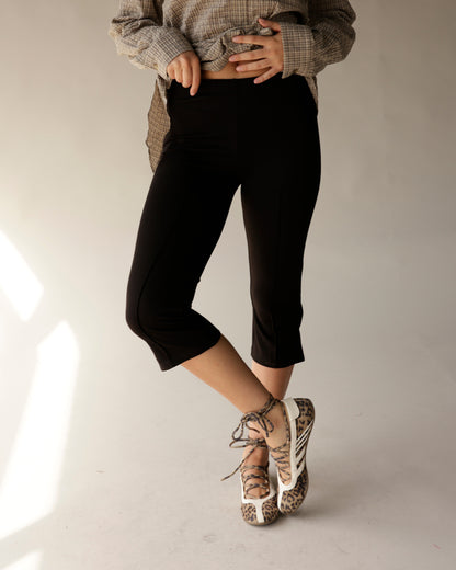 Black capri leggings with smooth fit and elastic waistband, styled casually