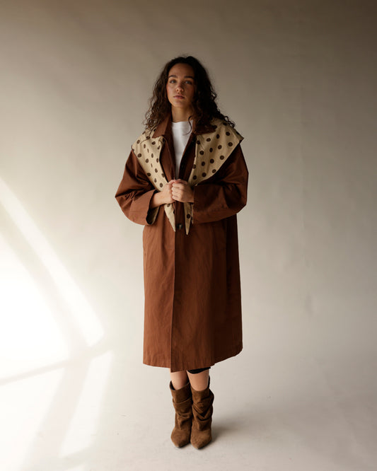 Oversized brown trench coat with beige polka dot detachable scarf collar, midi length