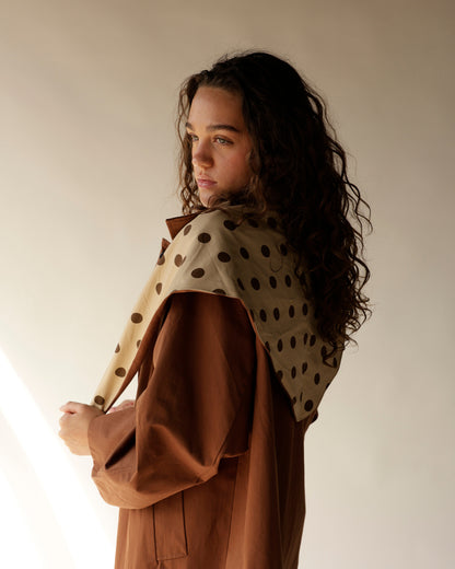 Oversized brown trench coat with detachable cream polka dot scarf, back view