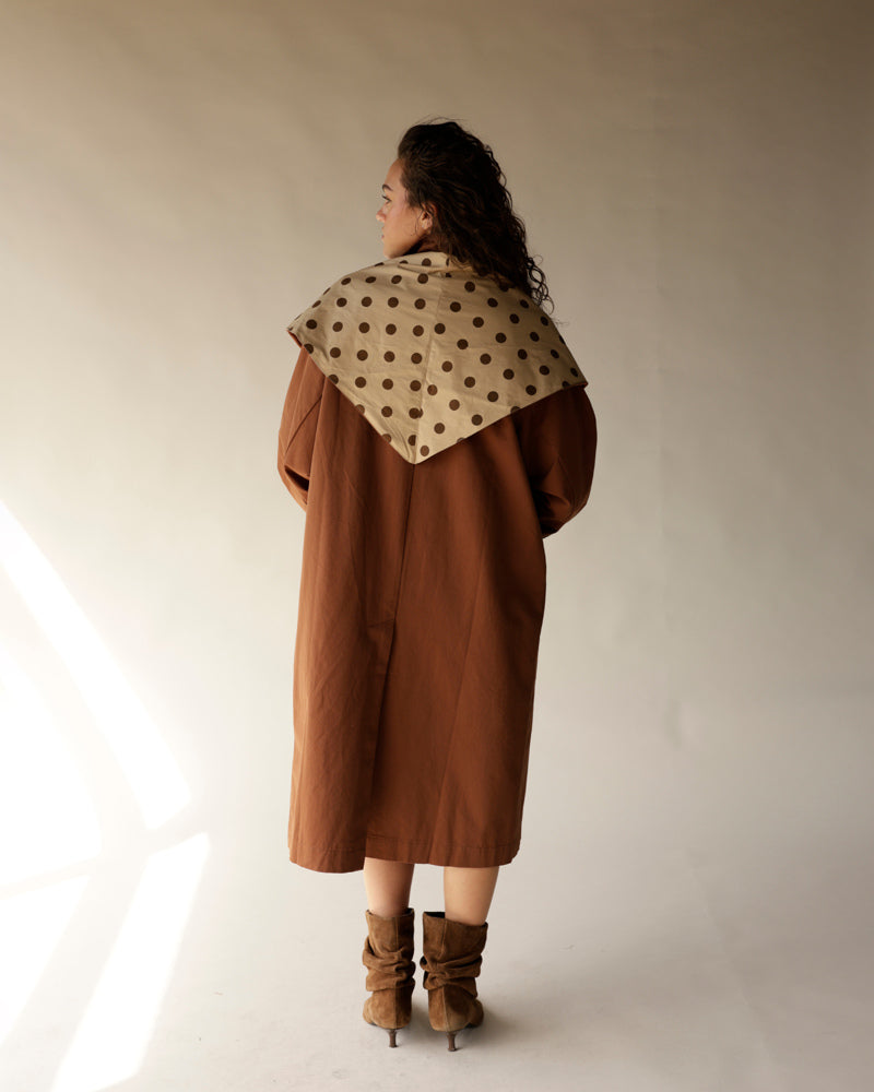 Oversized brown trench coat with detachable beige polka dot scarf and suede boots