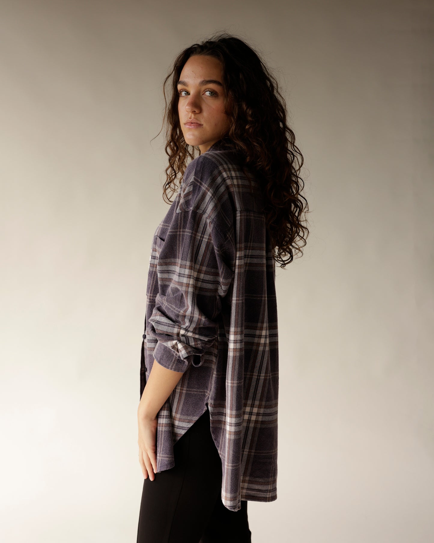 Navy plaid flannel button-up shirt with rolled sleeves, worn by a woman