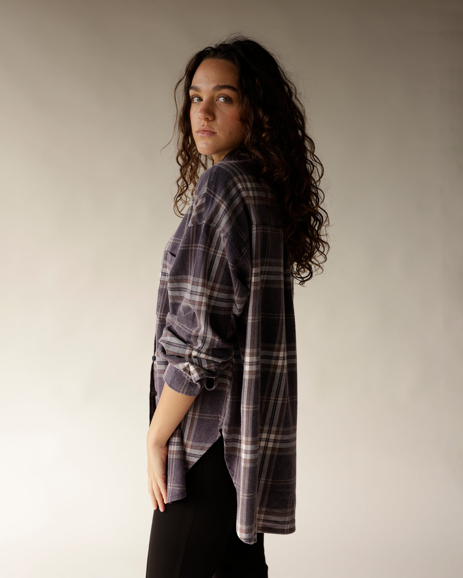 Navy plaid flannel button-up shirt with rolled sleeves, worn by a woman