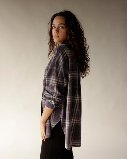 Navy plaid flannel button-up shirt with rolled sleeves, worn by a woman