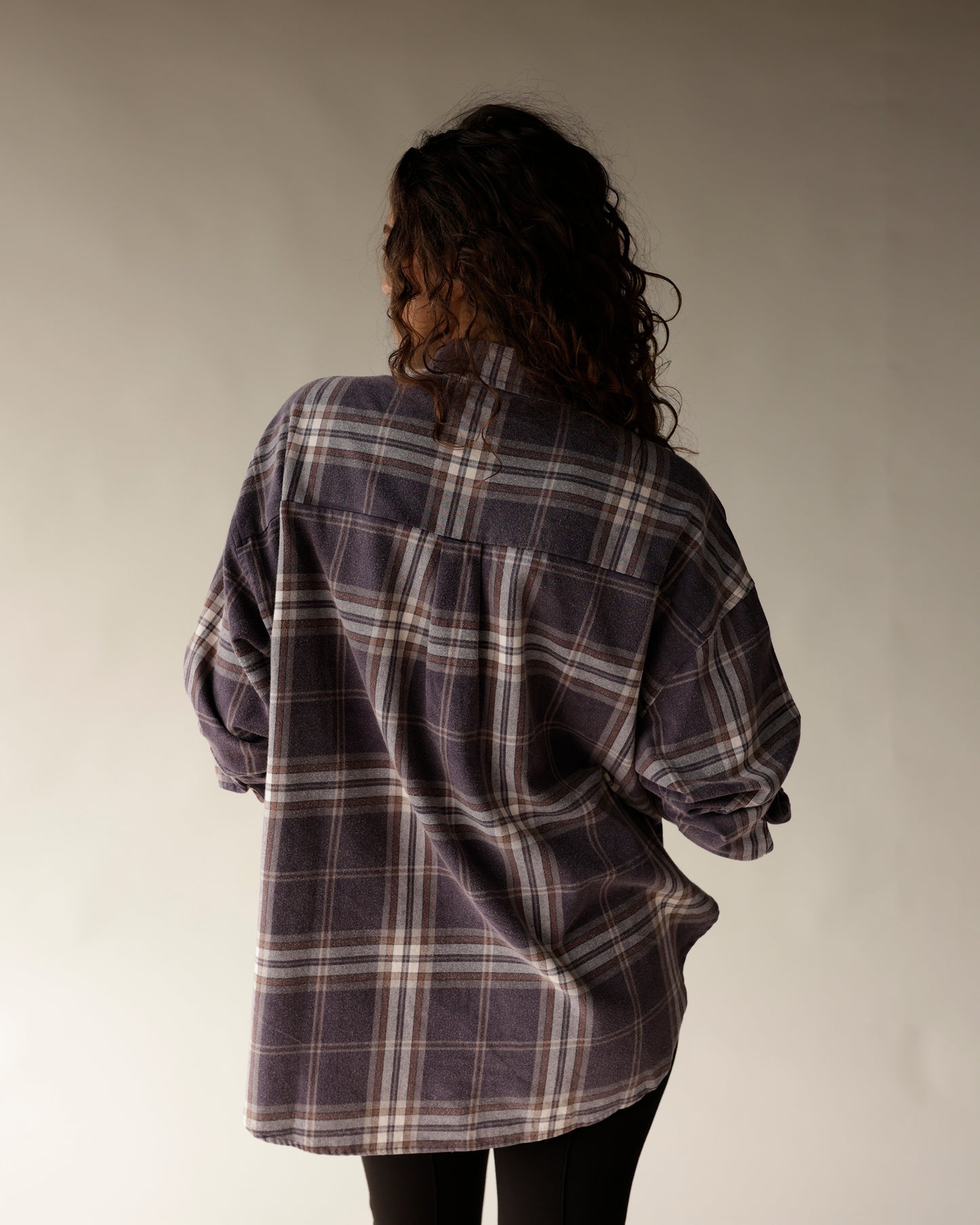 Navy plaid flannel oversized button-up shirt, back view, worn with black pants