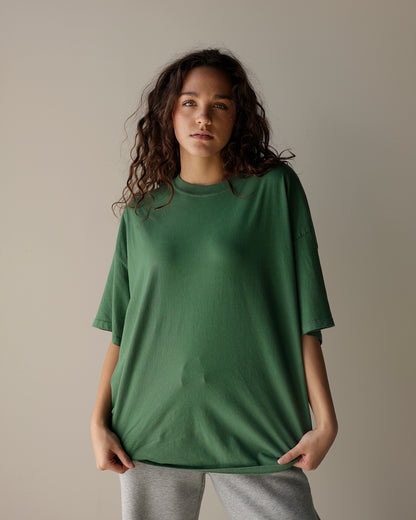 daydreamer oversized green crewneck t-shirt with dropped shoulders, relaxed short sleeves and a loose fit, styled with gray sweatpants.
