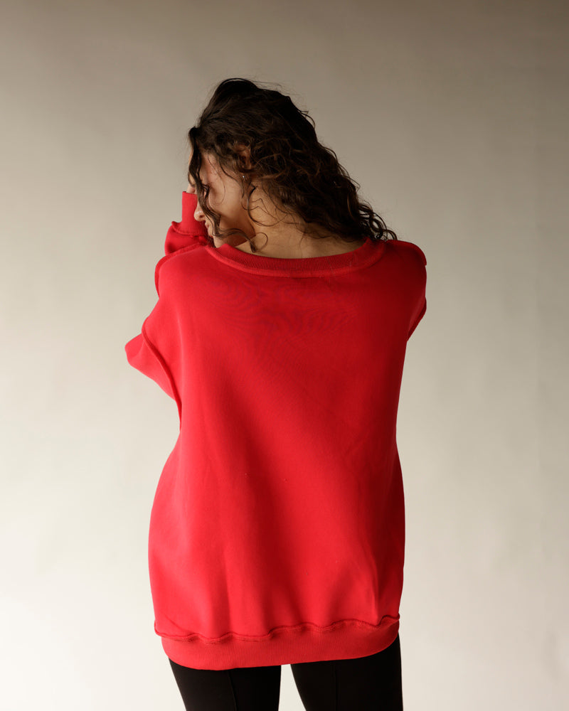 Red reversible split neck sweatshirt shown from the back on a female model