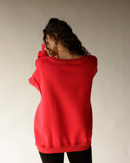 Red reversible split neck sweatshirt shown from the back on a female model