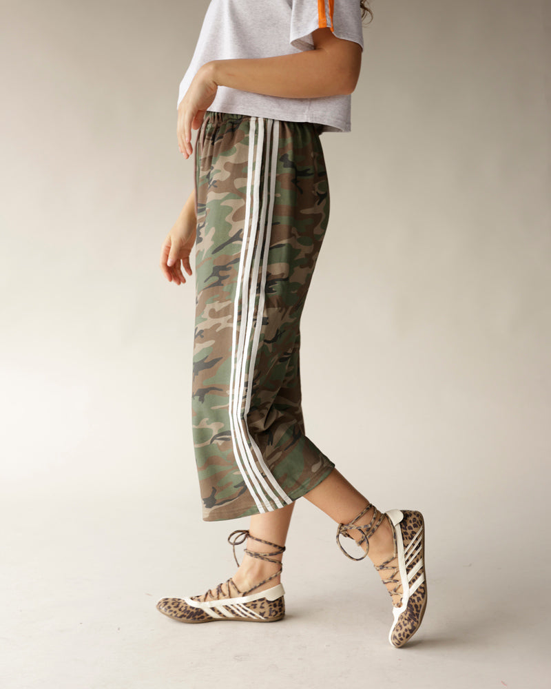 Camouflage cropped track pants with white side stripes, paired with leopard print shoes
