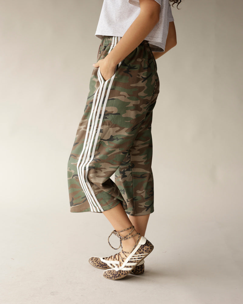 Camo print midi shorts with white side stripes, paired with leopard sneakers