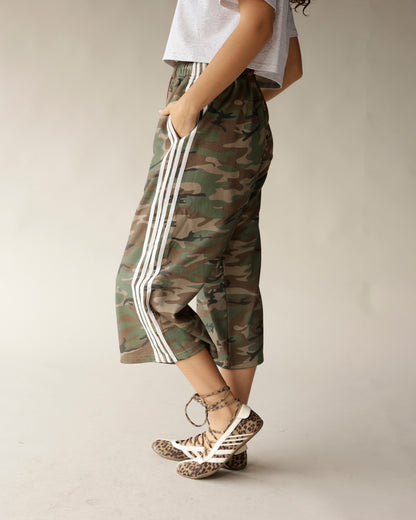 Camo print midi shorts with white side stripes, paired with leopard sneakers