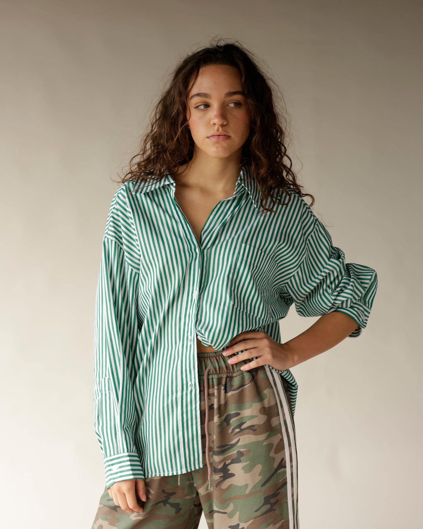Effortlessly chic, this green and white striped button-front women's top is a versatile addition to any wardrobe. 
