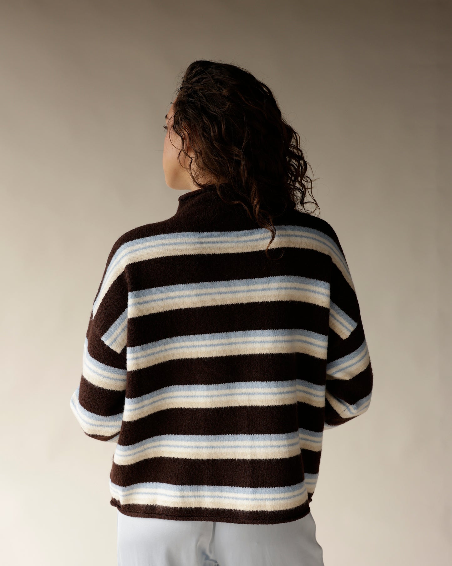 Brown striped mock neck cardigan with cream and blue stripes, back view