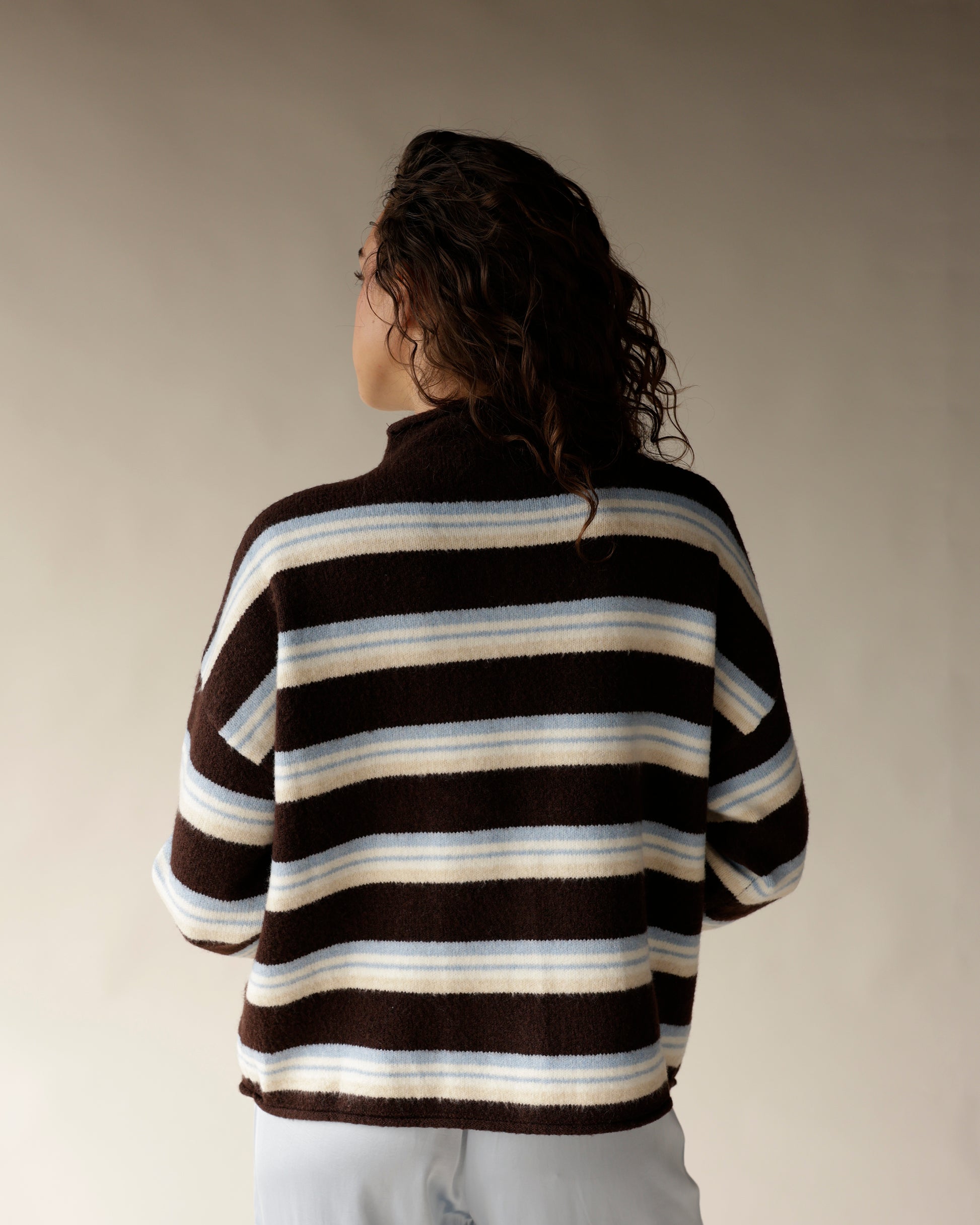 Brown striped mock neck cardigan with cream and blue stripes, back view