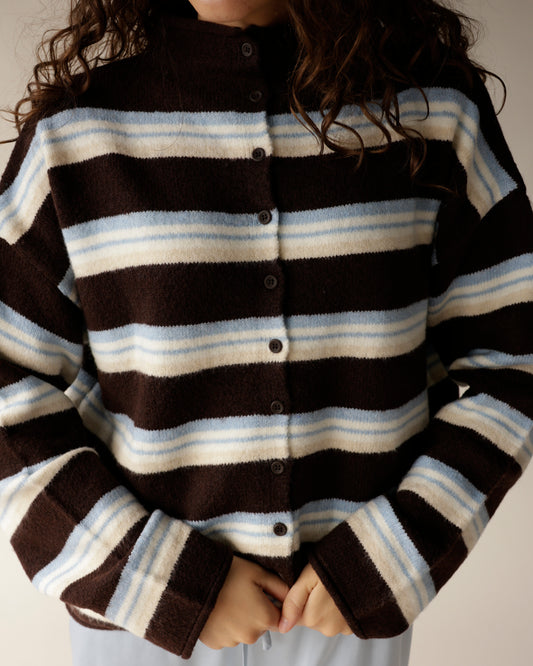 Add personality to your cool-weather look with the MICHELLE MOCK NECK STRIPE CARDIGAN, an oversized, button-front style in brown, blue, and cream stripes.