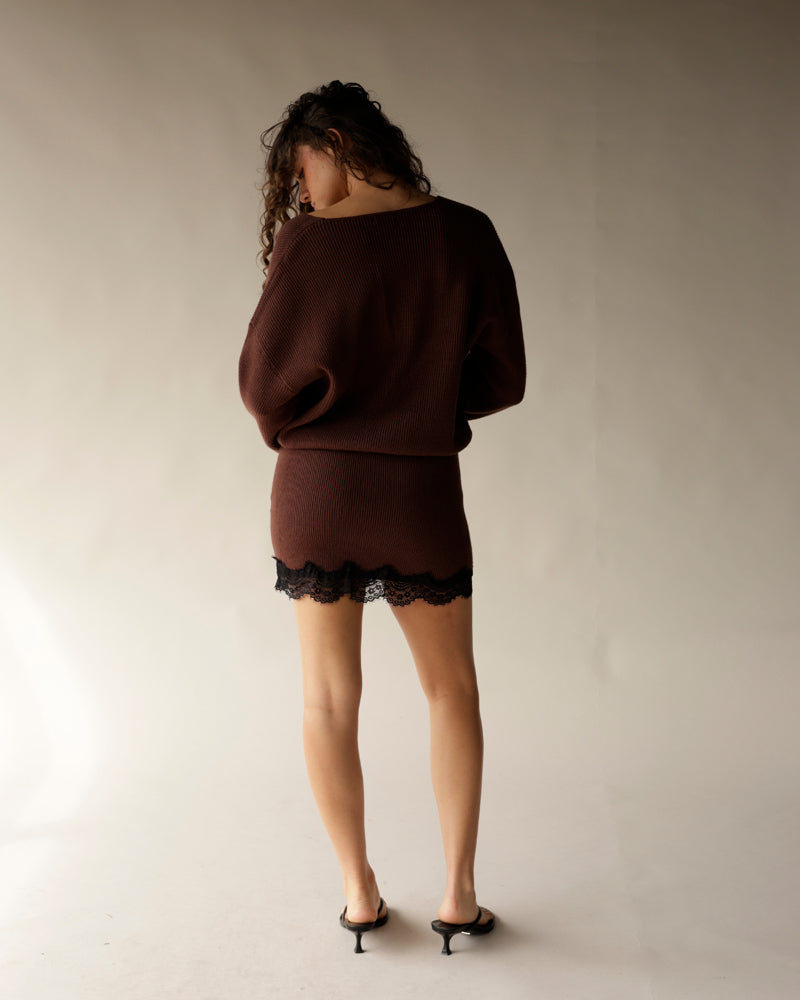 Brown ribbed knit mini dress with black lace hem, long sleeves, back view