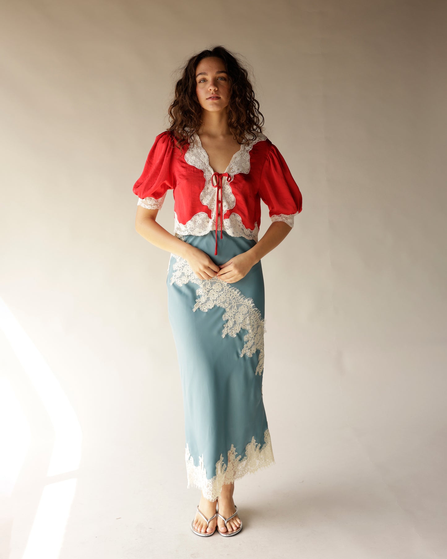 Dusty blue satin midi skirt with ivory lace trim and scalloped hem detail