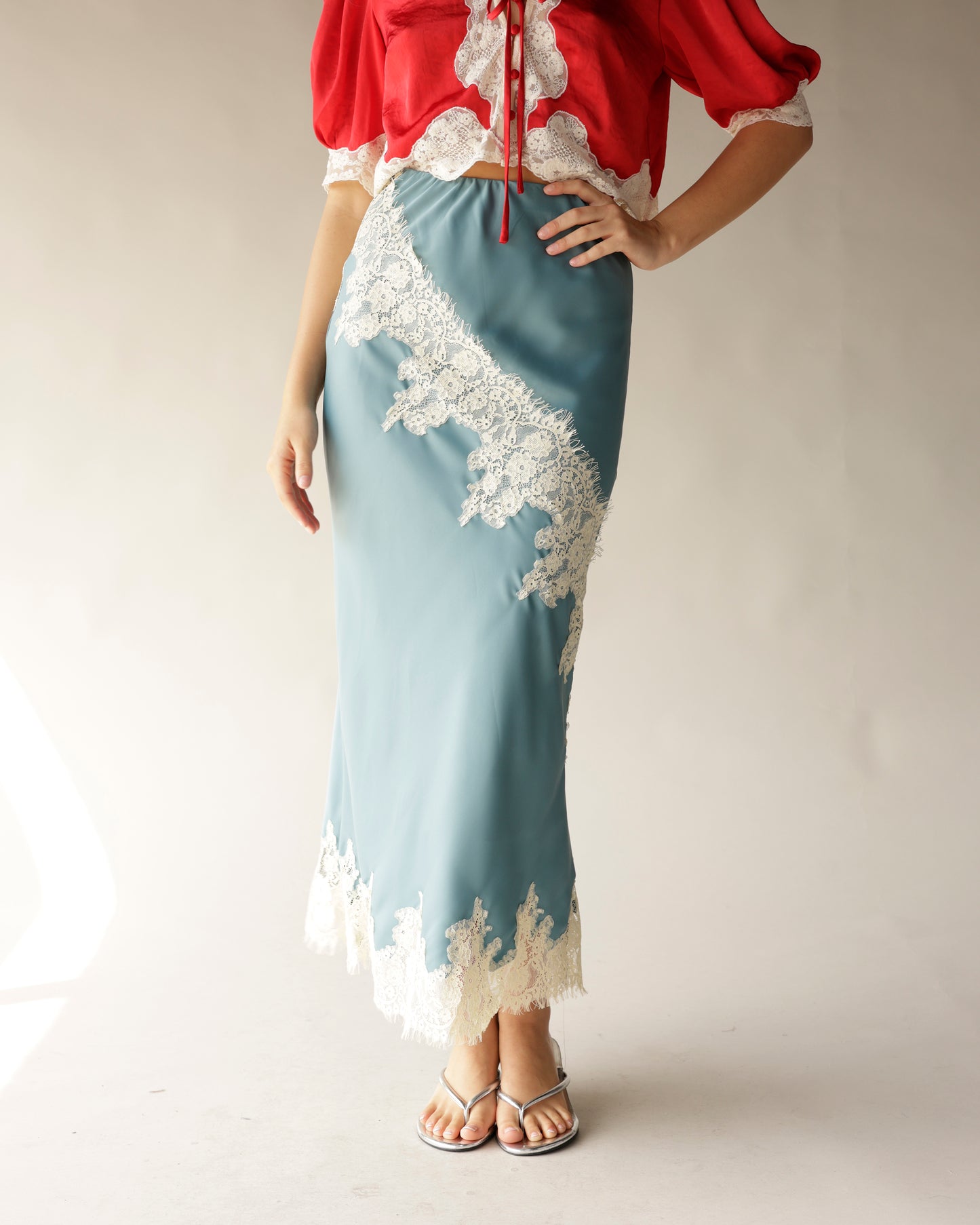Dusty blue satin midi skirt with cream lace appliqué trim and hem detail