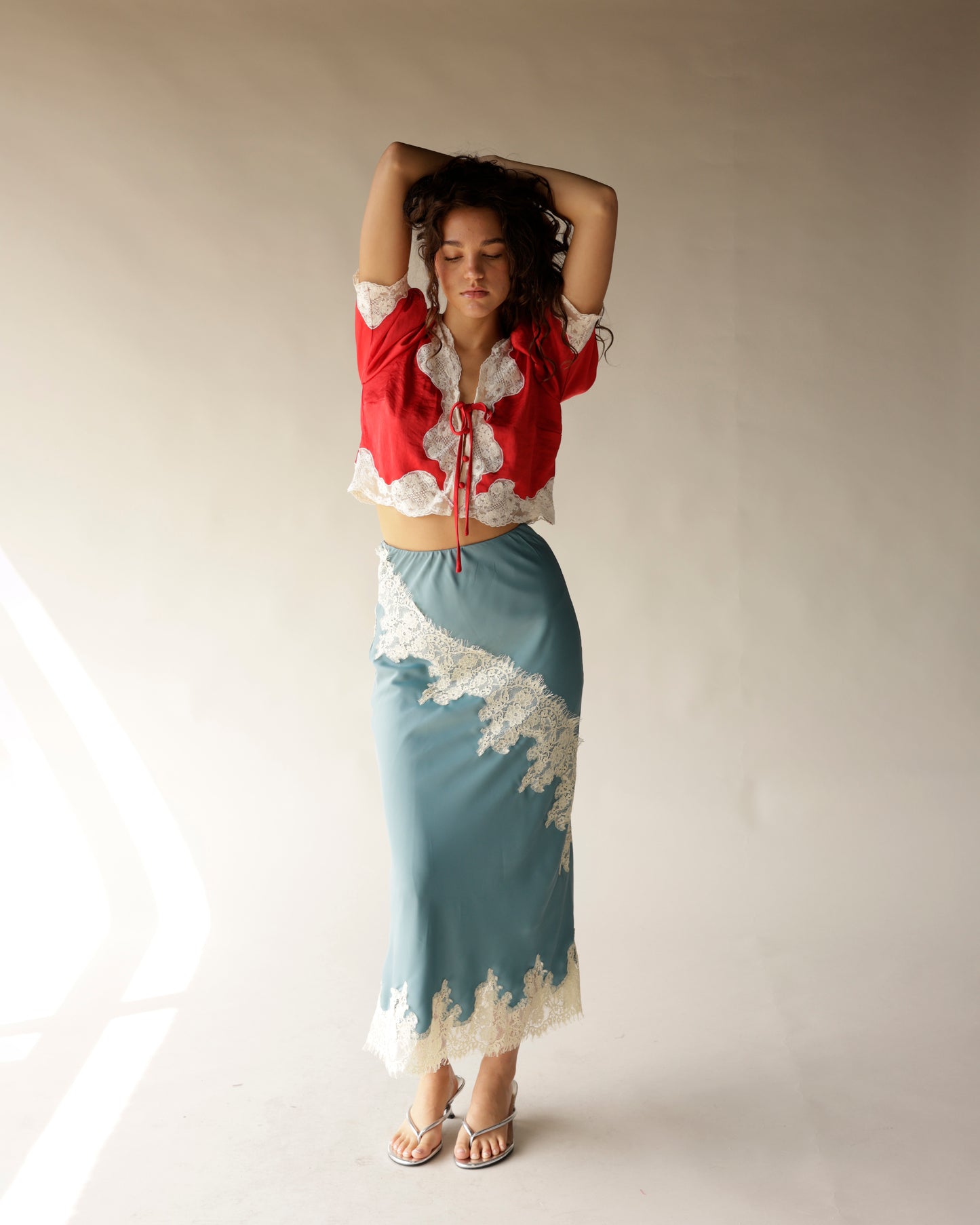 Dusty blue satin midi skirt with ivory lace trim and diagonal lace appliqué detail
