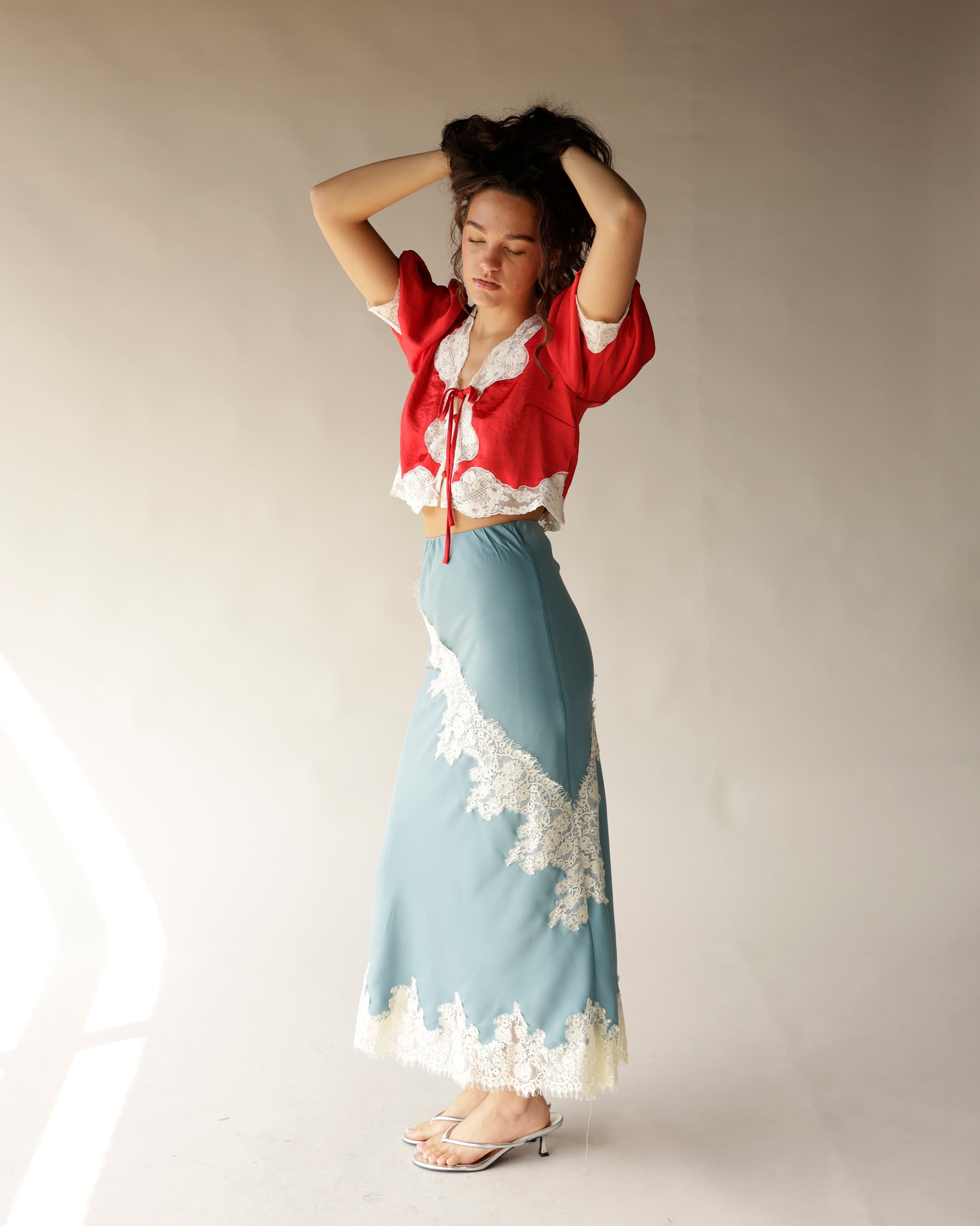 Dusty blue satin midi skirt with cream lace trim detail and floral appliqué hem