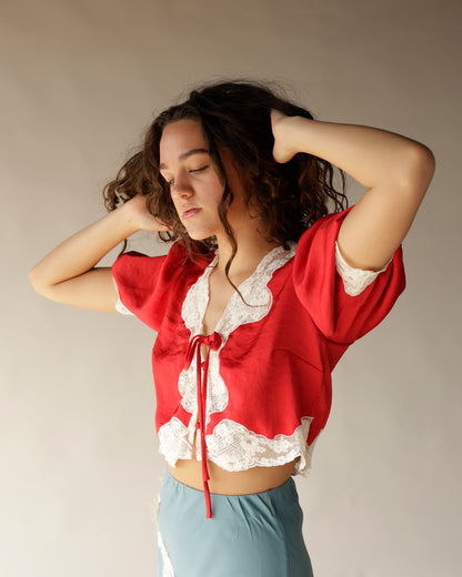 Red satin crop top with white lace trim and tie front closure