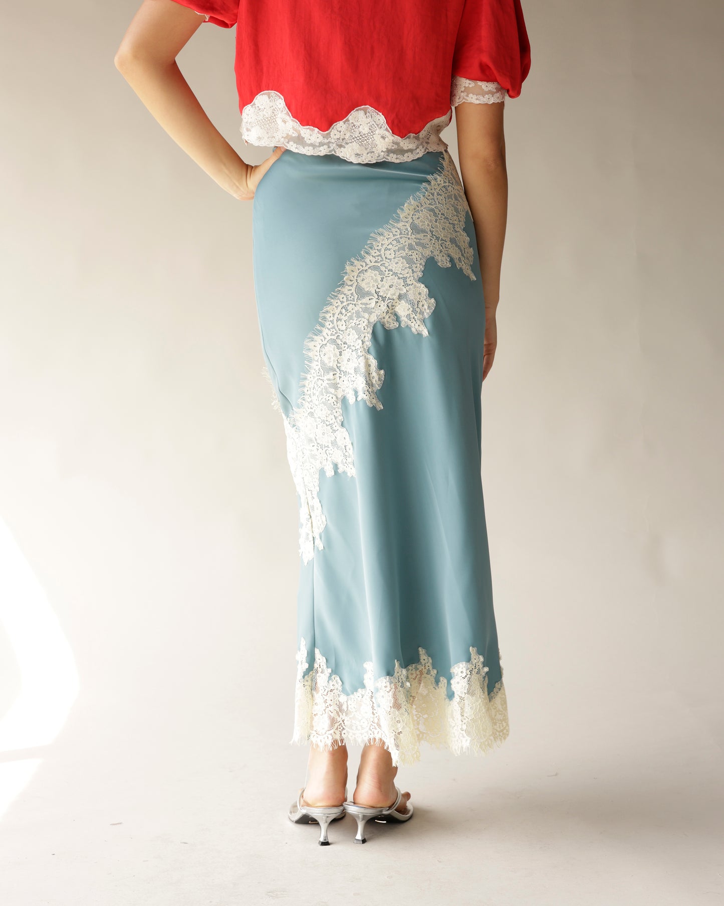 Dusty blue satin midi skirt with white lace appliqué trim, back view