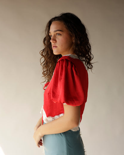 Red satin puff sleeve crop top with white lace trim collar and hem