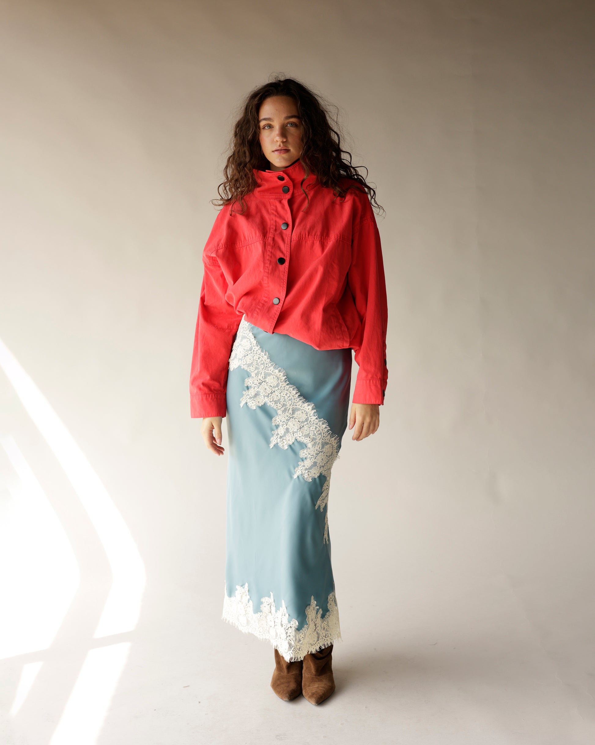 Dusty blue satin midi skirt with diagonal white lace trim and hem detail
