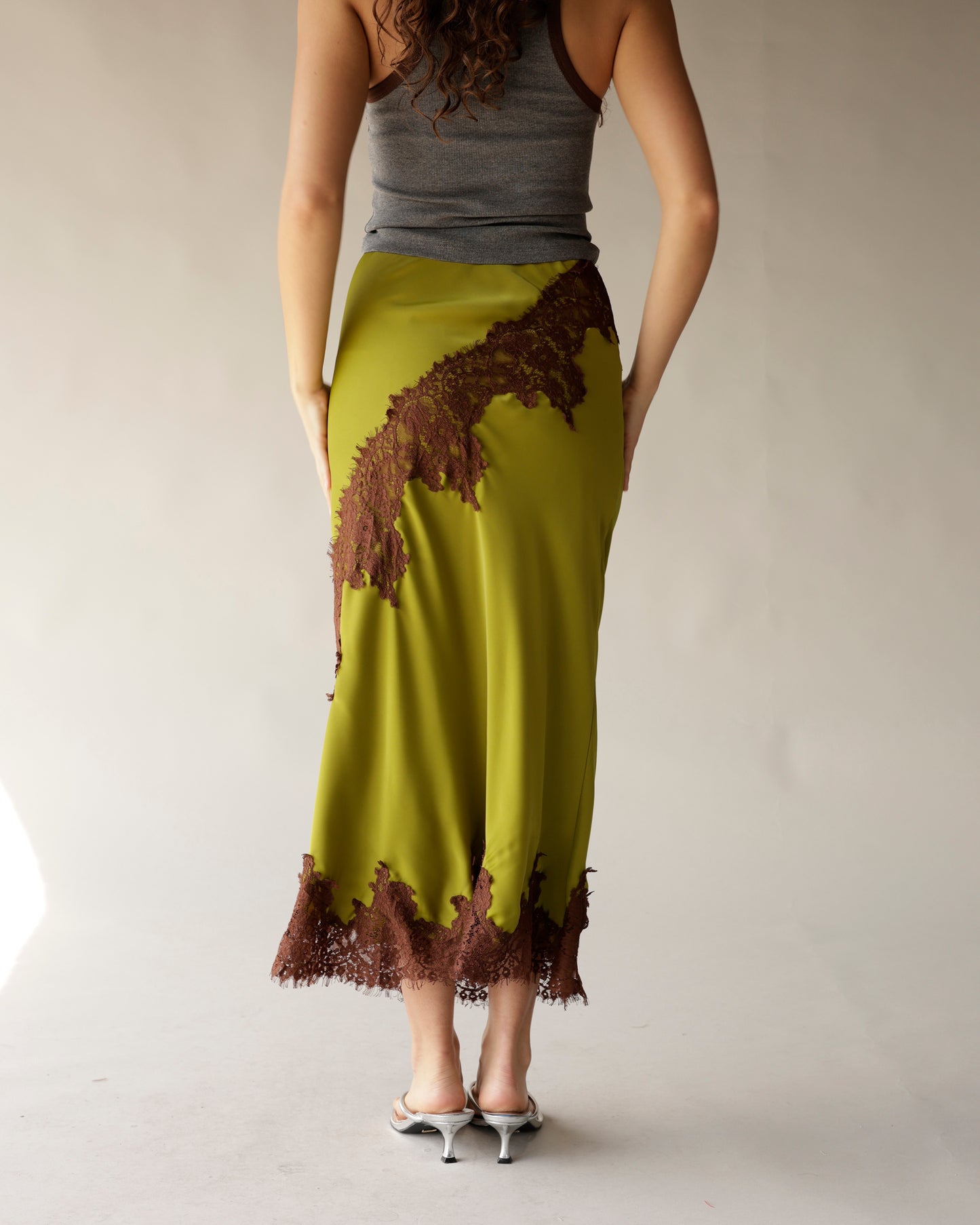 Olive green satin midi skirt with brown lace appliqué trim and hem detail