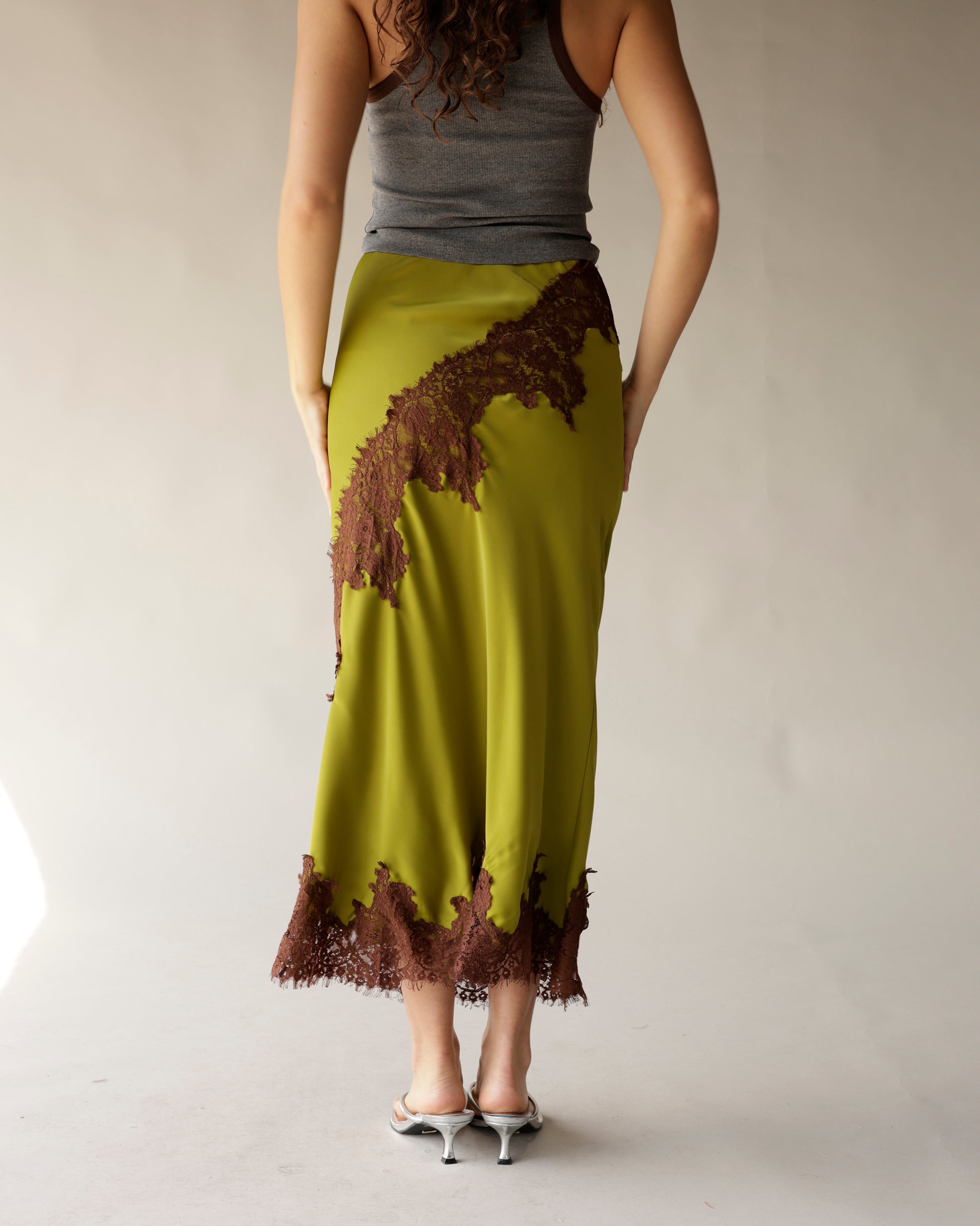 Olive green satin midi skirt with brown lace appliqué trim and hem detail