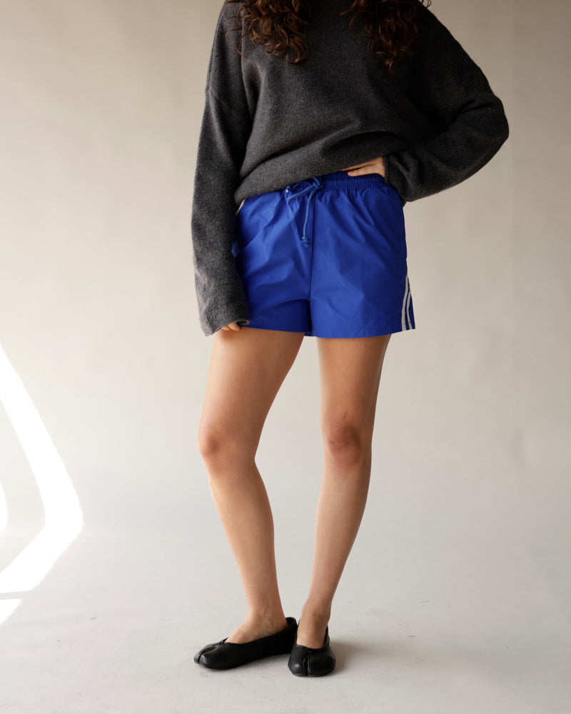 Royal blue athletic track shorts with white side stripes and drawstring waist