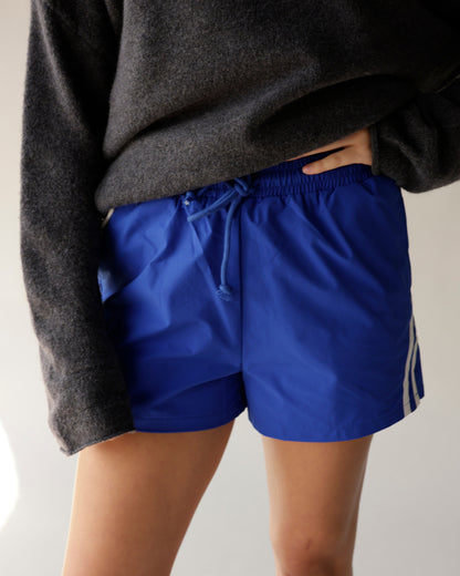 Royal blue athletic track shorts with white side stripes and drawstring waist