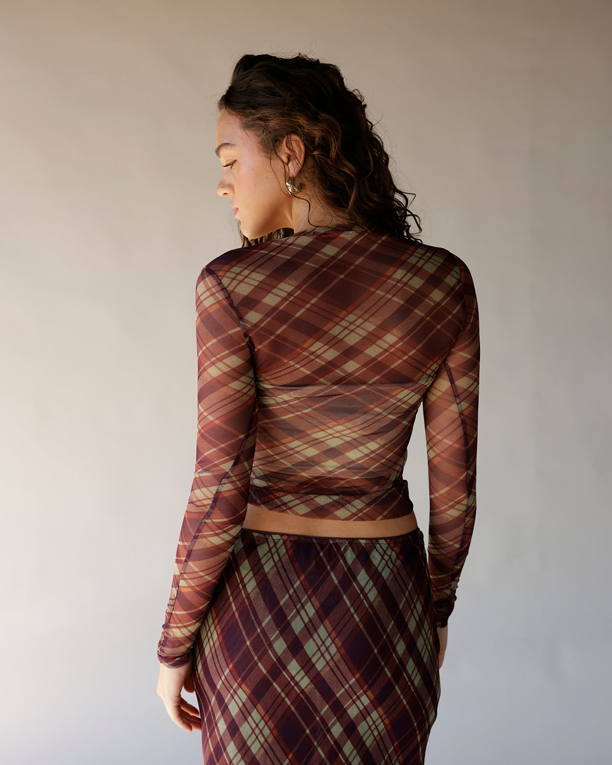 Brown plaid mesh long sleeve crop top with sheer fabric and fitted silhouette