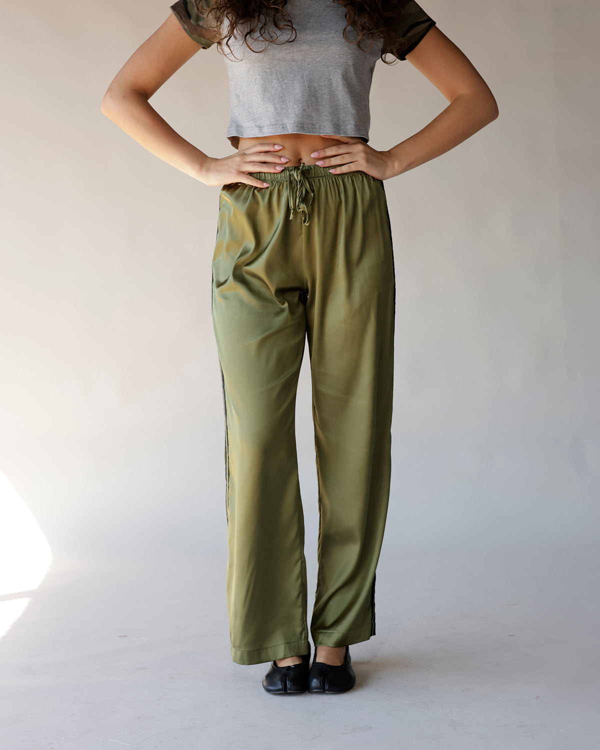 Olive green satin wide-leg track pants with drawstring waist and side stripe