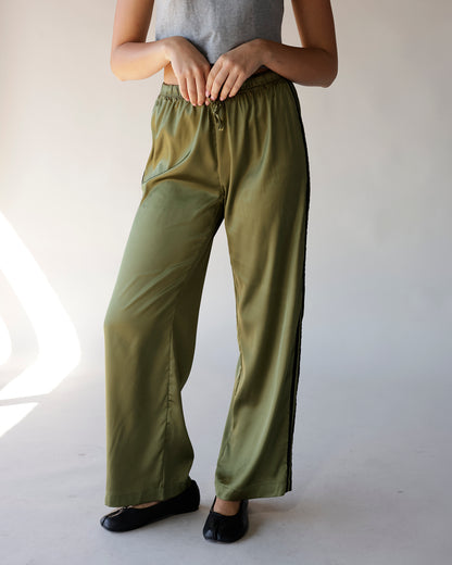 Olive green satin wide-leg track pants with black side stripe and elastic waist