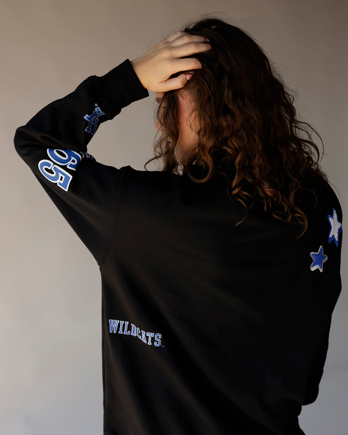 Black Kentucky Wildcats crewneck sweatshirt with blue star patches and sleeve graphics