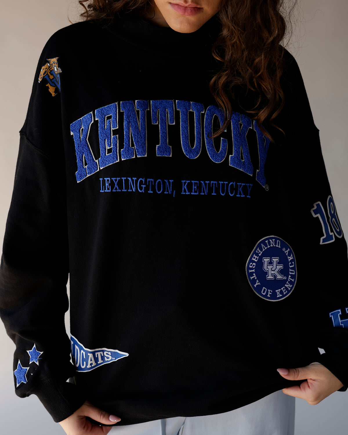 Black University of Kentucky crewneck sweatshirt with blue graphics and patches