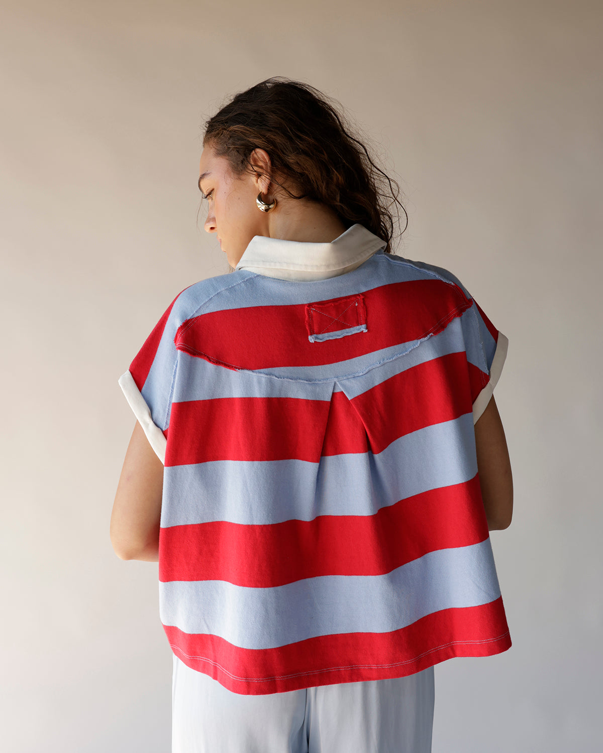 Red and blue striped crop polo top with white collar, back view
